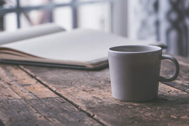 a coffee cup and notepad on a table